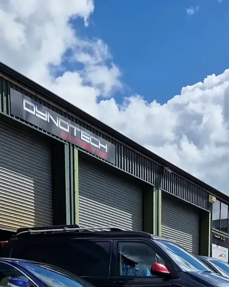 The Dynotech Autocentre workshop and its sign under a blue sky